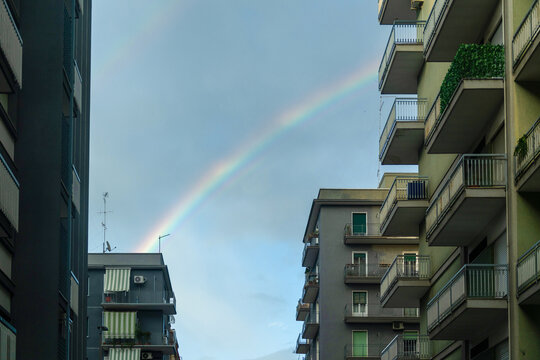 Rainbow Appears Over Buildings in Urban Area After Rain