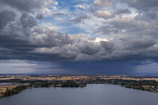 Heavy rain falling from dramatic storm clouds over an inland lake