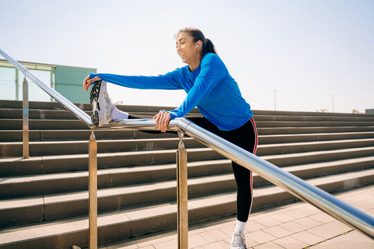A woman does stretching in the city