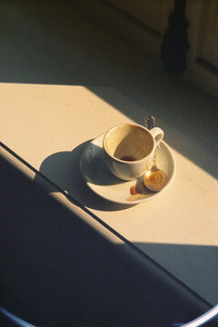 Detailed view shows an empty used coffee cup placed on a white table