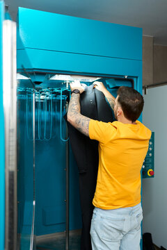 Man drying wetsuit in a dive center machine