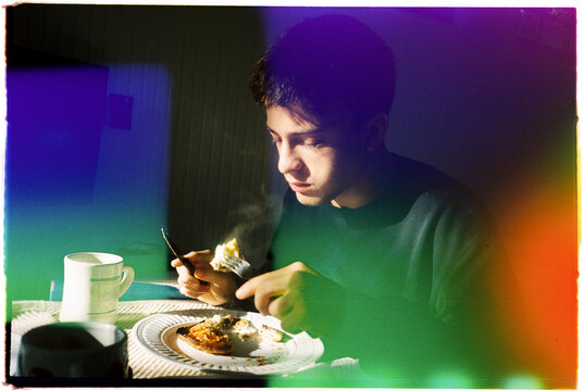 Young Person Enjoys Meal in Dim Light During Evening Time