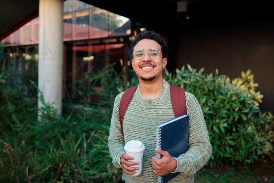 Student man holding coffee and notebook
