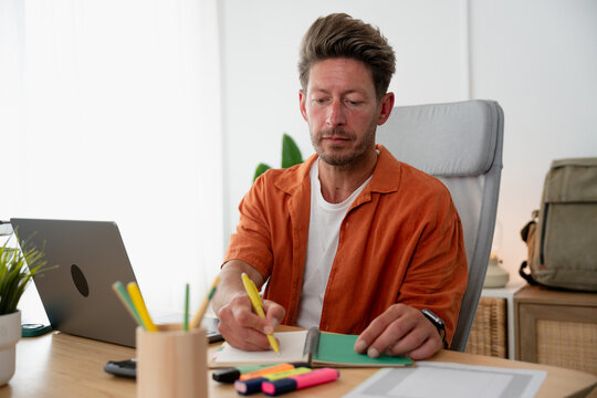 Man working from home writing notes