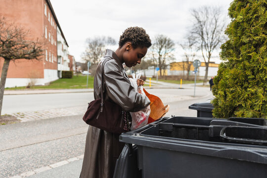 Woman Disposing Garbage in Outdoor Recycling Bin