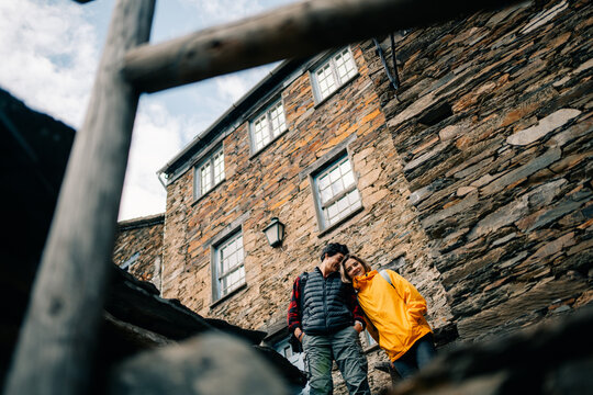 Couple Enjoys Time Near Stone Building in Outdoor Setting