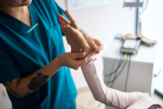Therapist applying electrode glove for neurostimulation therapy