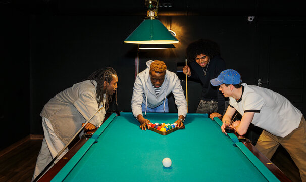 Group of friends playing pool together in a pub