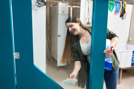 Woman cleaning glass door in dive center