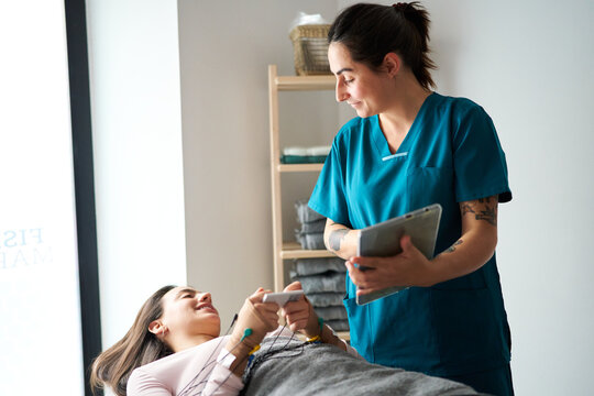 Physiotherapist assisting patient with neurostimulation at clinic