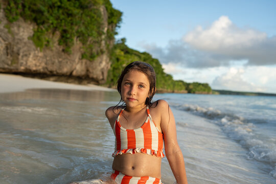 Girl standing in shallow ocean near shore