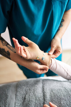 Physiotherapist applying neurostimulation on patient's hand