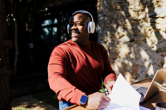 Man enjoying outdoor remote work with headphones