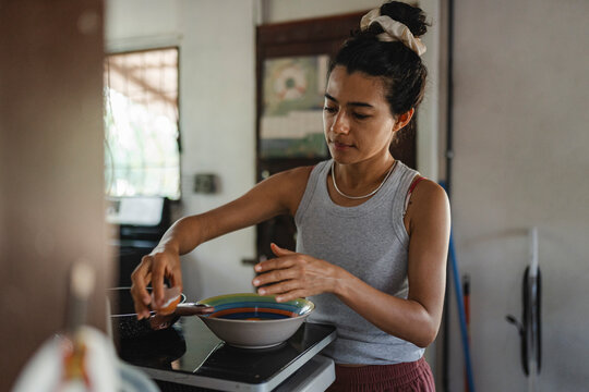 Woman cooking in kitchen preparing healthy meal