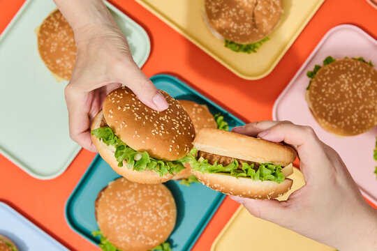 Hands Picking a Hamburger. Fast, finger food.
