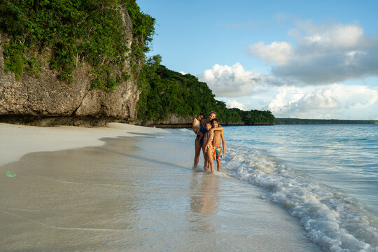 Family walking along shallow shoreline