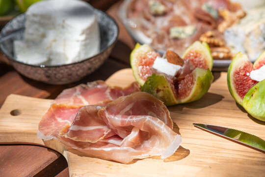 Fig and Prosciutto Platter on a Wooden Board in a Sunny Setting