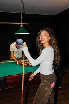 Friends enjoying fun game of pool at night