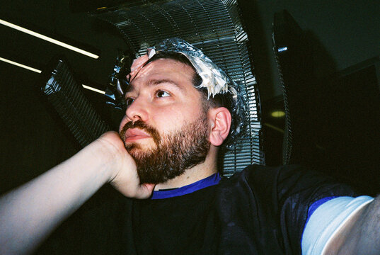 Man sitting with foils in hair during coloring
