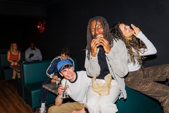 Diverse group enjoying burgers and drinks at a bar