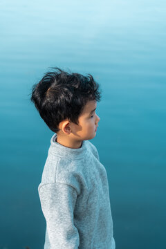 boy standing by blue water