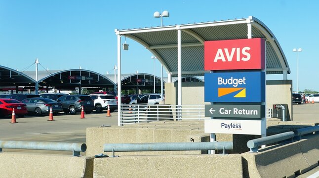 Northern Texas, U.S.A - May 31, 2026 - Rental car return zone with Avis, Budget, and Payless signage, traffic cones, and parked vehicles by Dallas Fort Worth International Airport