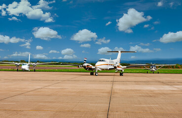 Air ambulance and propeller planes parked on airport tarmac  under blue sky.Air ambulance and propeller planes parked on airport tarmac  under blue sky. © poco_bw