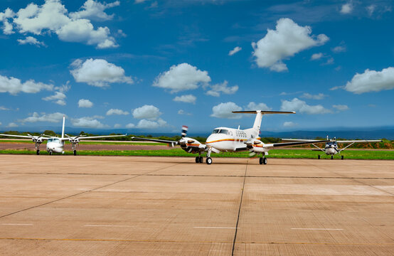 Air ambulance and propeller planes parked on airport tarmac  under blue sky.Air ambulance and propeller planes parked on airport tarmac  under blue sky.