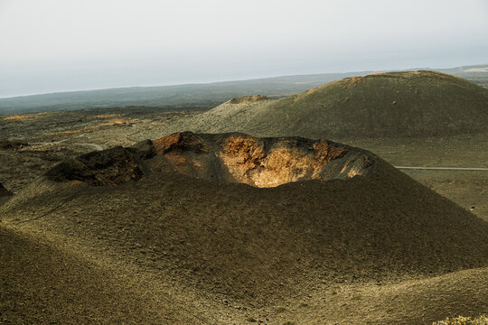 Volcanic landscape with crater and surrounding hills in dry region