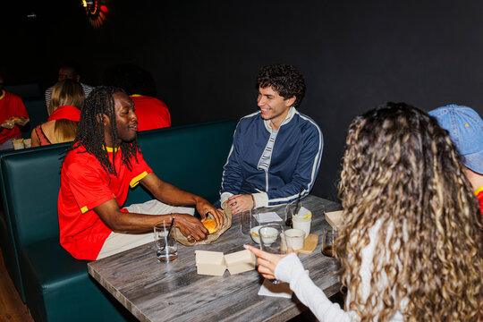 Group of friends enjoying dinner, conversing in restaurant