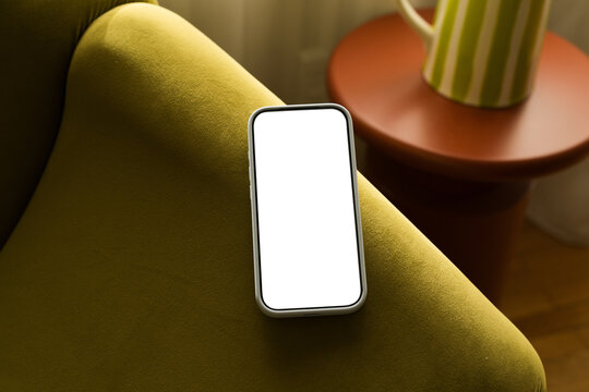 Mobile phone on couch with empty screen ready for use    