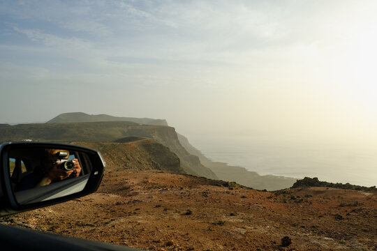 Scenic coastal view captured from a car window during sunset