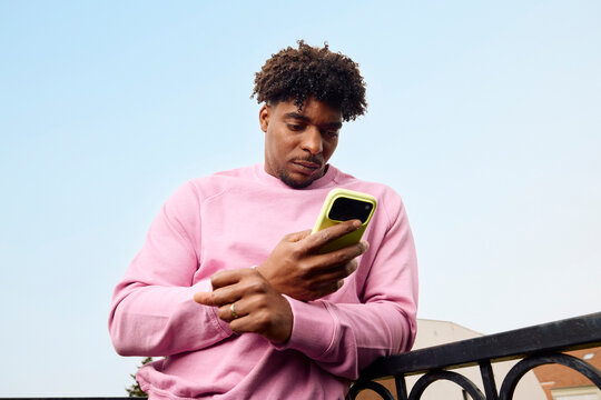 Man Using Smartphone on the Balcony