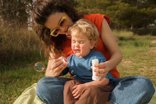 Colorful picnic in spring with family enjoying bubble fun in nature