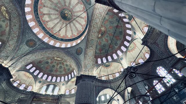 Breathtaking wide view of Blue Mosque interior in Istanbul, Turkey. Majestic architecture with huge columns, historic painted domes, and low chandeliers, perfect for holy Ramadan background.