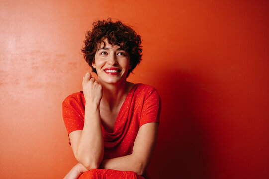 Young woman portrait over red background.