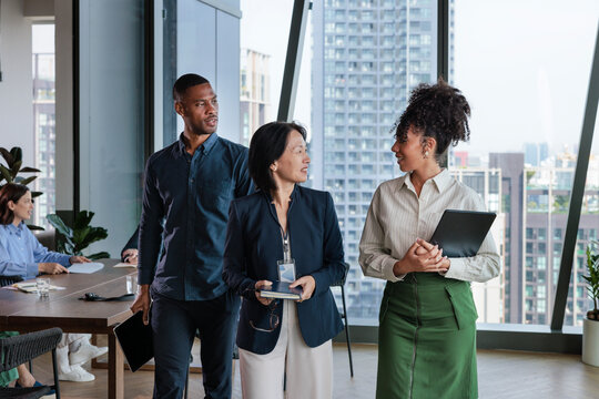 Diverse business team in modern office with city view.