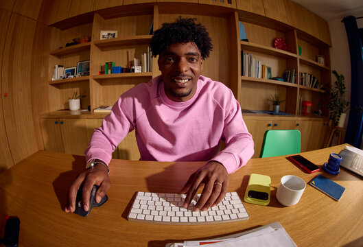 Man engaged in work within a cozy home library setting.