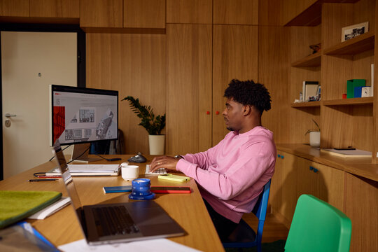 Man sits back at a desk, working on a freelance project