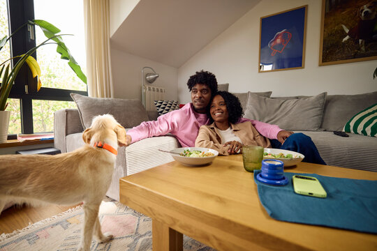 Happy couple spends time together at home with their dog
