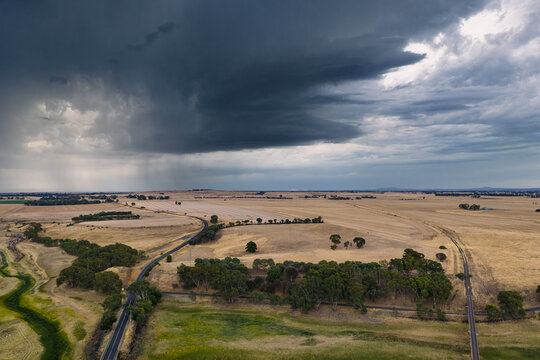 Heavy rain falling from a dramatic storm clouds over a dry lake bed