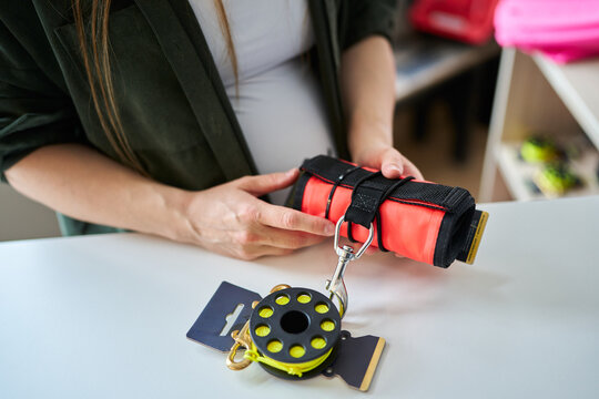 Person checking scuba dive safety equipment at shop