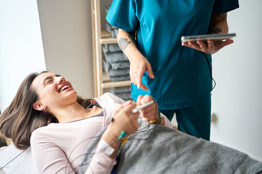 Smiling woman receiving neurostimulation therapy at clinic