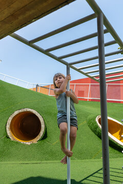Child Climbing Pole on Modern Playground