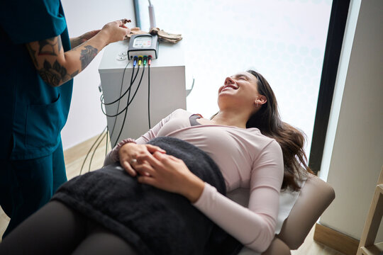 Woman receiving neurostimulation physiotherapy treatment at clinic