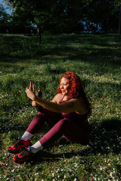 Athletic woman with a natural physique making a video call outdoors