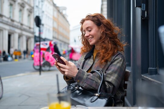 Using smartphone at outdoor London pub