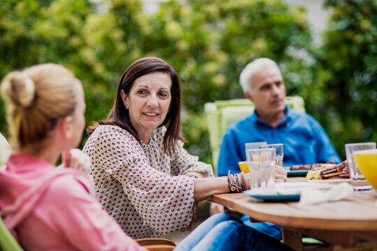 Family gathering outdoors enjoying communication during dinner