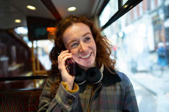 Smiling while talking on phone in London bus