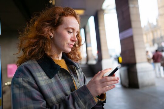 Using smartphone under city arcade
